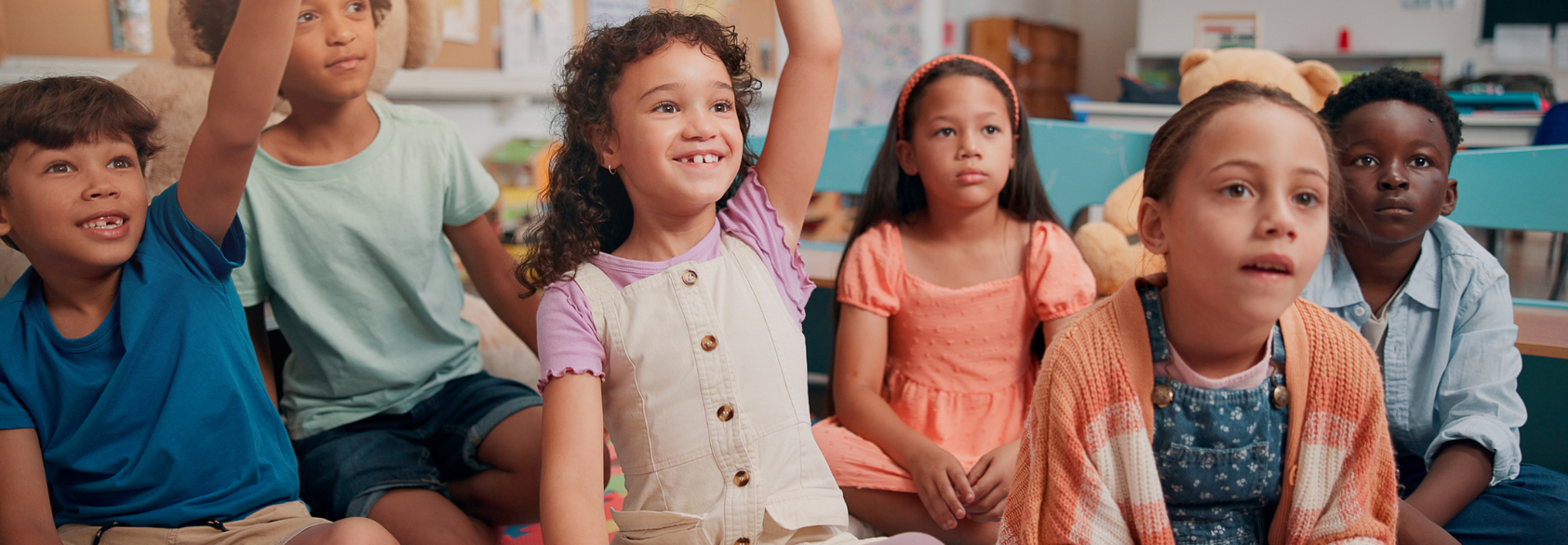 Students, children and hands raised with answer in classroom for feedback, lesson question and knowledge. People, happy and problem solving on floor for learning development, education quiz and smart stock photo